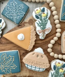 Decorated Thanksgiving cookies shaped like pie slices, fall leaves, and flowers created in a holiday cookie decorating class in Castle Rock