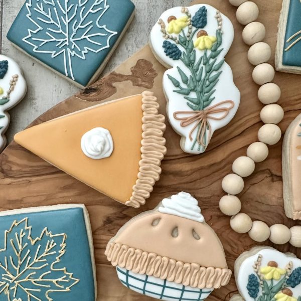 Decorated Thanksgiving cookies shaped like pie slices, fall leaves, and flowers created in a holiday cookie decorating class in Castle Rock