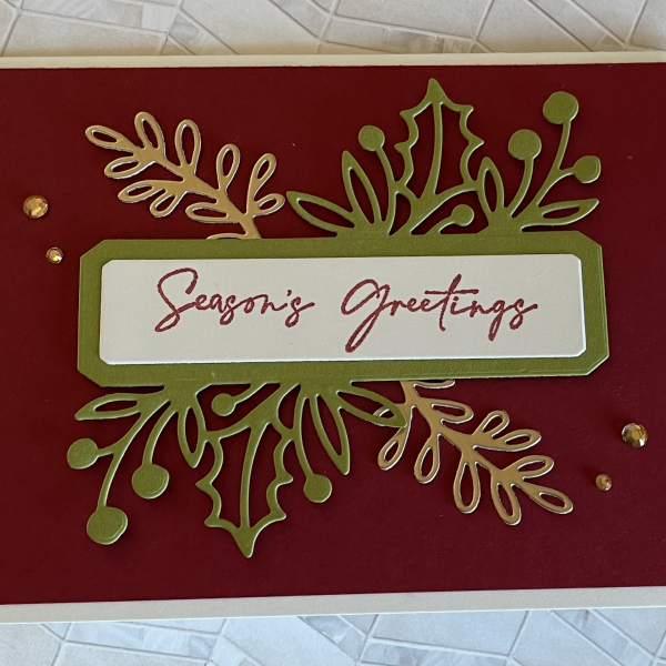 Holiday card made TriArts class with words "Seasons Greetings" and gold accents.