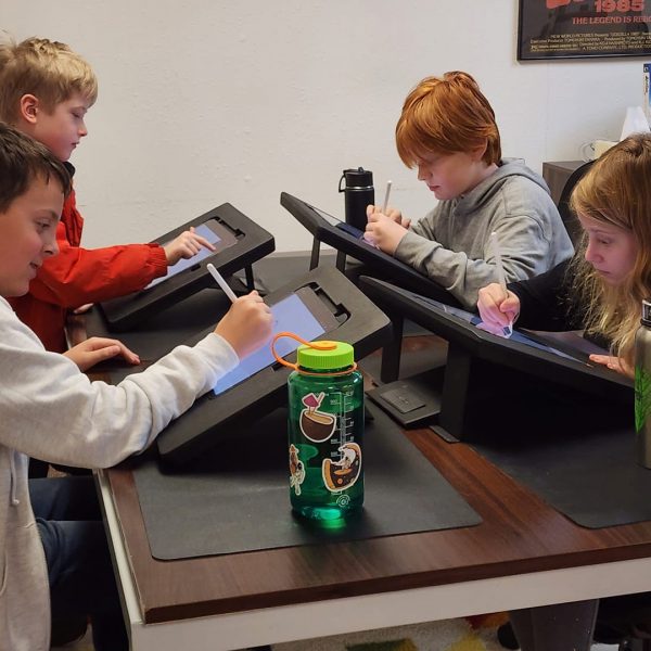 group of children learning digital arts on tablets